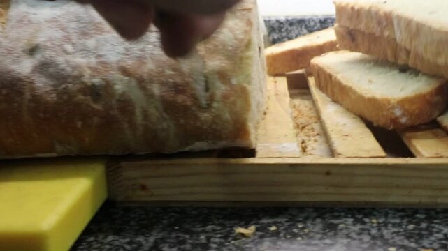 Man cutting a rustic bread with Kalamata Olives made from 2 kilos of flour, homemade