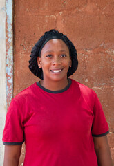 village african woman portrait, outdoors in the nature ,satin hair cap bonnet , at home ,wall behind