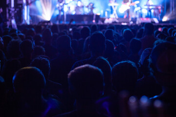 crowd of people at concert, standing spectators listin music at rock festival, backlight