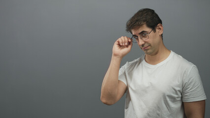 Man runs hand through hair and touches forehead while adjusting glasses in a studio six frame...