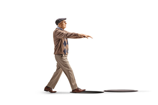 Full length profile shot of an elderly man sleepwalking toward an open manhole