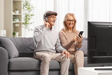 Happy ature couple enjoying media