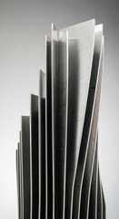 Obraz premium A closeup of a brushed metal object featuring multiple vertical stepped and twisted fins on a grey background