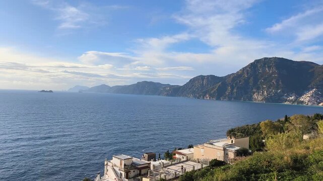 Panoramic view of the entire Amalfi Coast from Positano to Punta Campanella, with Capri island visible in the distance along the Mediterranean Sea, Italy.