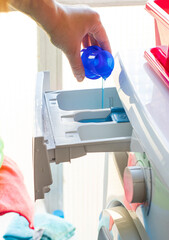 process of adding laundry detergent to modern washing machine tray