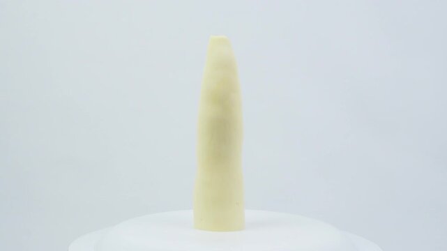 Peeled Raw Cassava Root Rotating on White Background