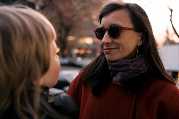 Mom and daughter at walk in winter snowless city