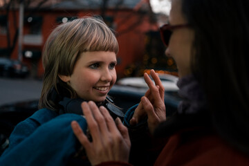 Mom and daughter at walk in winter snowless city