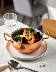 Cataplana de marisco presentada en un bistr&oacute; moderno en un ambiente acogedor