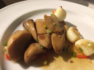 a dish of Stir-fried King Oyster (Eryngii) mushrooms with garlic and chili slices, isolated on white.