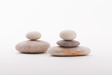 Two cairns of balanced stones against a bright white background, demonstrating balance, stability, and calm.