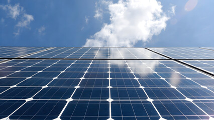 Close-up texture of solar panel photovoltaic cells with bright sun flare reflection, renewable clean energy technology background.