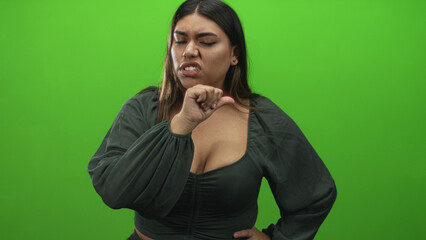 Woman with hand on hip, points two fingers and points at camera, touches nose and taps temple in studio; defiance.