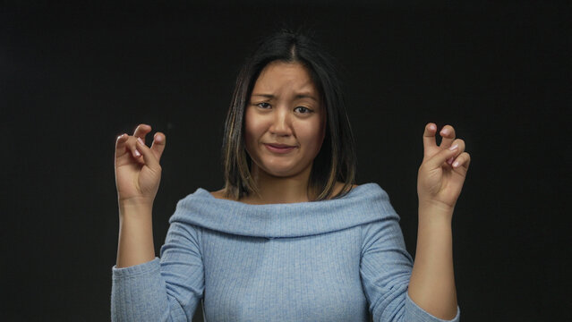 Woman expressing confusion in thoughtful gestures over isolated black background, wearing blue in contemplative mood and unsure expression with hands raised in quote symbol. - Powered by Adobe