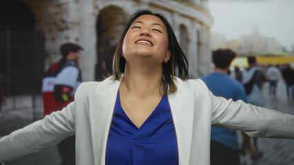 Woman with open arms smiling joyfully near the roman coliseum outdoors in rome city setting on a...