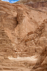 Layered sandstone cliff in White Canyon, Wadi Qunai, Sinai Peninsula, Egypt. Eroded rock formations shaped by wind and time in an arid desert environment.