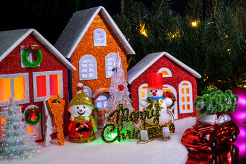 Under a large tree in a small town, near the houses, there are snowmen and Christmas trees with letters and keys nearby