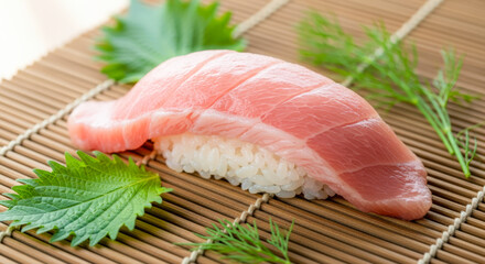 高級大トロ寿司のクローズアップ。脂ののったマグロの寿司、シソともに竹のマットに美しく盛り付けられている。