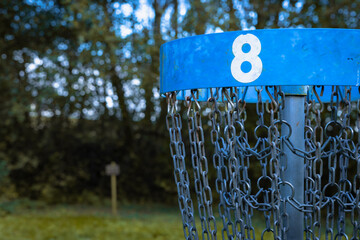 blue discgolf basket on hole number 8