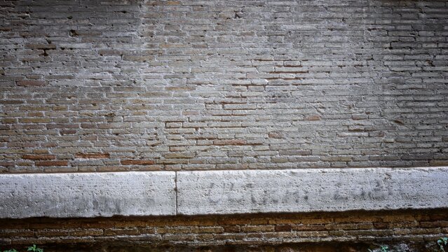 Weathered brick wall texture in sharp focus across a building exterior, detailed mortar and aged bricks create tactile surface; backplate background copyspace calm.