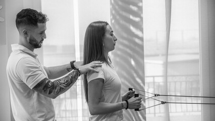 Young woman receiving back physiotherapy exercises in a modern rehabilitation center