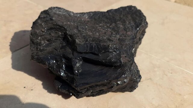 Piece of Anthracite Coal in 4K. High-Grade Hard Coal with Shiny Carbon Surface and Sharp Texture, Representing the Highest Rank of Coal Captured in Cinematic High-Detail Industrial, Geological Footage