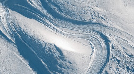 Fototapeta premium Aerial view of abstract wave patterns in snow on a mountain, winter texture