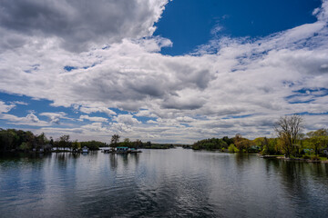 Small wooded islands on calm river under dramatic cloudy sky