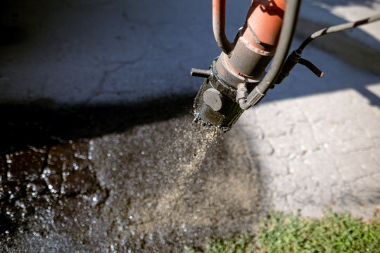 Road patcher machine repairing asphalt surface