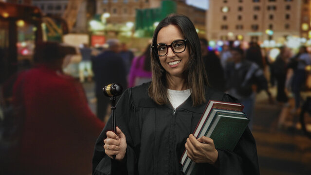 Woman judge holding gavel and stack of books, smiling with visible hands on gavel and books in street; confidence authority. - Powered by Adobe