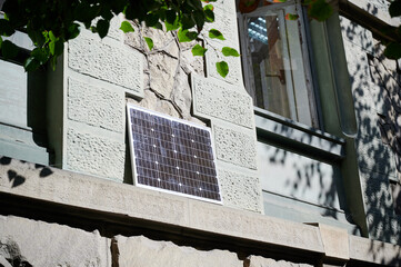 Photovoltaic solar panel in front of historical building. Concept of integration of sustainable renewable energy sources into old architecture.