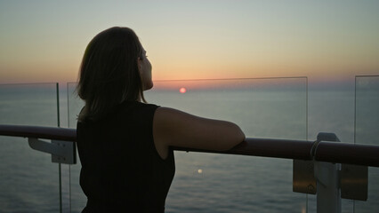 Woman leans on cruise ship rail, looking toward the horizon, showing a bare shoulder and resting hand to neck on deck at sunset; serenity.