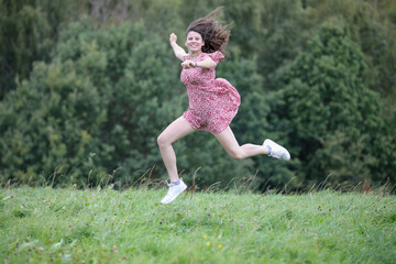 H&uuml;bsche Teenagerin h&uuml;pft und springt in der Natur