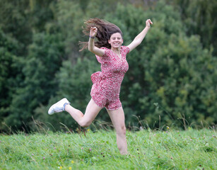 H&uuml;bsche Teenagerin h&uuml;pft und springt in der Natur