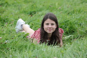 Gl&uuml;ckliche Teenagerin liegt im Gras