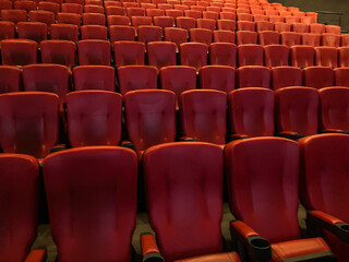 Fototapeta premium VIP movie theater with red seating, soft shadows, neutral floor contrast, natural daylight t