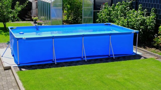 A large 2x4 meter swimming pool with clear water sits on a green lawn in the garden. A beautiful garden with a greenhouse and various plants provides a relaxing area for the whole family.