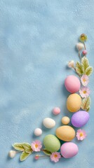 Colorful Easter egg and flower decoration on a light blue background, creating a festive spring holiday border for greeting card or invitation.