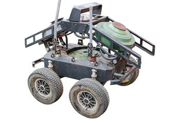 Robotic mine-laying ground drone with off-road wheels and a central, rounded body The device has a flat metallic platform and operates under controlled lighting conditions