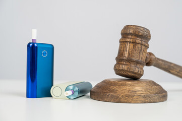 Judge's gavel and electronic cigarette. Smoking ban. Tobacco heating systems. 