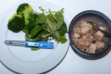 Healthy salad with tuna and Ozempic pen for diet concept