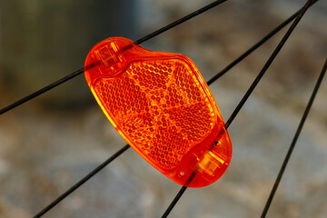 Orange bicycle reflector providing safety on bike wheel