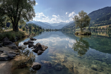 Fototapeta premium Alpine lake embracing clear water showing mountain reflections