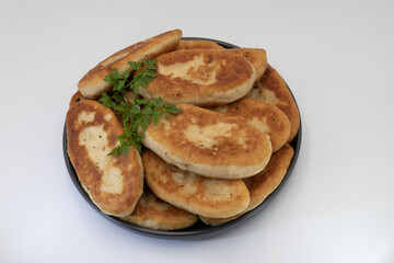 Traditional home baked fried potato pies with crispy crust and soft potato filling, classic домашняя выпечка served on plate, isolated on white background.