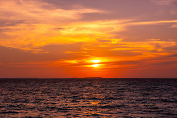 Fototapeta premium Beautiful sunset. Tranquil closeup calm sea water waves with palm trees. Tropical island beach landscape exotic shore coast. Summer vacation, holiday amazing nature, Maldives.