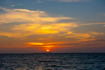 Fototapeta premium Beautiful sunset. Tranquil closeup calm sea water waves with palm trees. Tropical island beach landscape exotic shore coast. Summer vacation, holiday amazing nature, Maldives.
