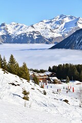 Fototapeta premium Aerial view Courchevel ski resort under clouds by winter, Rhône alps, France, Mont Blanc mountain in the background