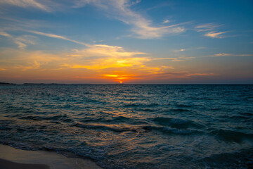 Obraz premium Beautiful sunset. Tranquil closeup calm sea water waves with palm trees. Tropical island beach landscape exotic shore coast. Summer vacation, holiday amazing nature, Maldives.