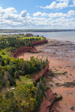Aerial drone views at Burntcoat Head Park in Nova Scotia reveal extreme tidal forces, where low tide exposes forested islands and towering rock formations shaped by the world&rsquo;s highest tides.