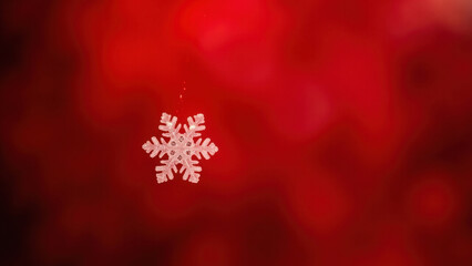 Single delicate snowflake ornament hanging against a blurred red background with bokeh lights